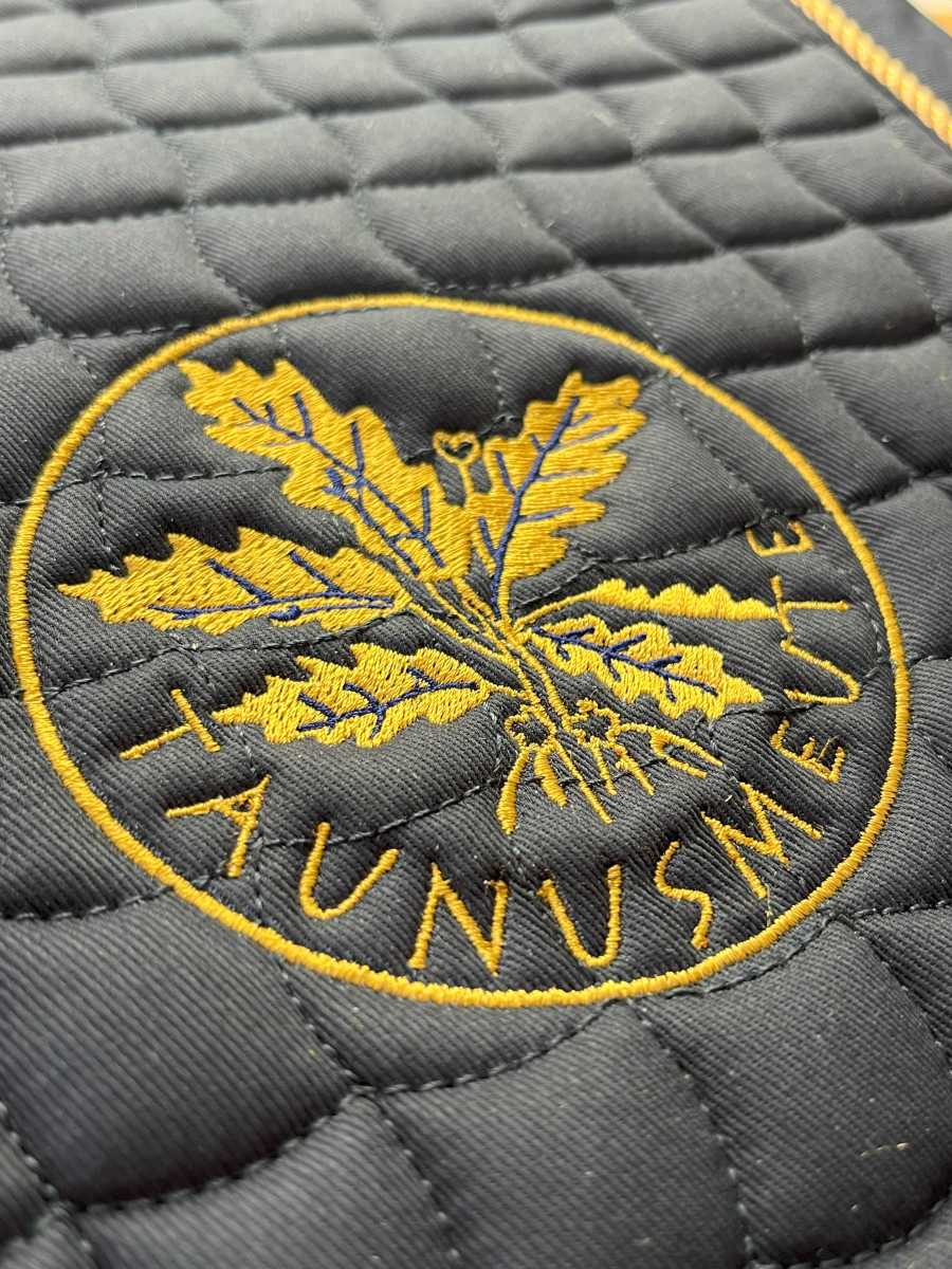 Taunusmeier – rundes Vereinsemblem in Gold auf schwarzer Schabracke